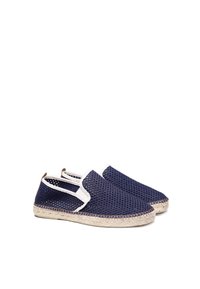 Zapatos deslizantes de malla azul marino con acentos blancos y suela de yute. Presenta paneles laterales elásticos para facilitar su uso.
