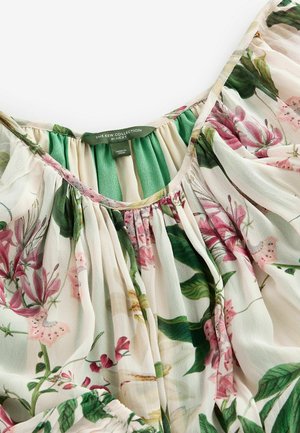 Blomstret bluse med en cremet baggrund og pink og grønne botaniske prints. Plisseret halsudskæring og blødt, letvægtsstof.