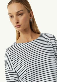 Gestreepte top van lichtgewicht stof, voorzien van marineblauwe en witte horizontale strepen, een ronde halslijn en een relaxed-fit. Gladde textuur en casual ontwerp.