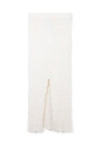 Jupe blanche texturée avec un ourlet ondulé et une fente frontale, fabriquée à partir d'un tissu léger, conçue pour un ajustement fluide.