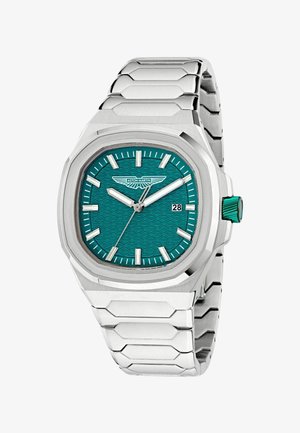 Hõbedane metallist käekell türkiissinise tekstuurse sihverplaadiga, valgete tundiindeksite, kuupäevaklahviga kell 3 ning Aston Martini logoga kell 12 all.