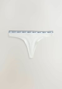 Bijele gaćice tanga od pamuka, s plavo-crnim elastičnim pojasom s natpisom "NEXT". Glatka tekstura, minimalistički dizajn.