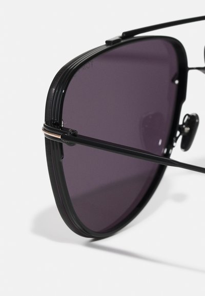 Occhiali da sole aviator neri con lenti viola scuro, montatura in metallo sottile e design elegante. Presentano un accento argento sul ponte e sui cuscinetti per il naso.