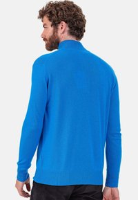 Pull-over bleu vif en maille douce. Doté d'un col montant et de poignets et ourlet côtelés. Texture lisse avec une coupe ajustée.