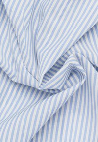 Tessuto a righe blu chiaro e bianco, che mostra una texture liscia con strisce verticali sottili e regolarmente distanziate. Il materiale appare morbido e si drappeggia facilmente.
