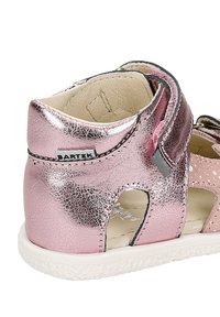 Růžové metalické kožené sandály s výřezovým designem, suchým zipem, bílou strukturovanou podrážkou a akcenty s puntíky. Připevněná značka Bartek.