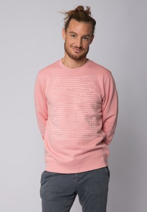 Roze sweatshirt met lange mouwen, gekenmerkt door een wit lijnpatroon van gestileerde katten en golven over de voorkant. Zacht katoenmateriaal.