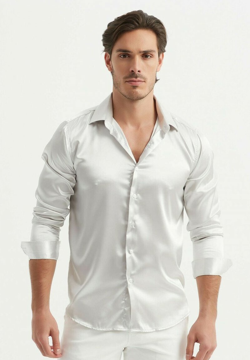 Chemise blanche en satin avec un col pointu, manches longues retroussées et fermeture à boutons sur le devant. Texture lisse et finition brillante.