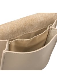 Beige faux läderhandväska med en slät yta, som har ett stort centralt fack, två innerfickor och en kontrasterande mjuk beige foder.