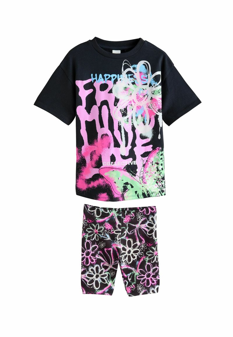 T-shirt en coton noir avec un graphique floral rose et du texte blanc, associé à un short noir avec des motifs floraux colorés et des accents.