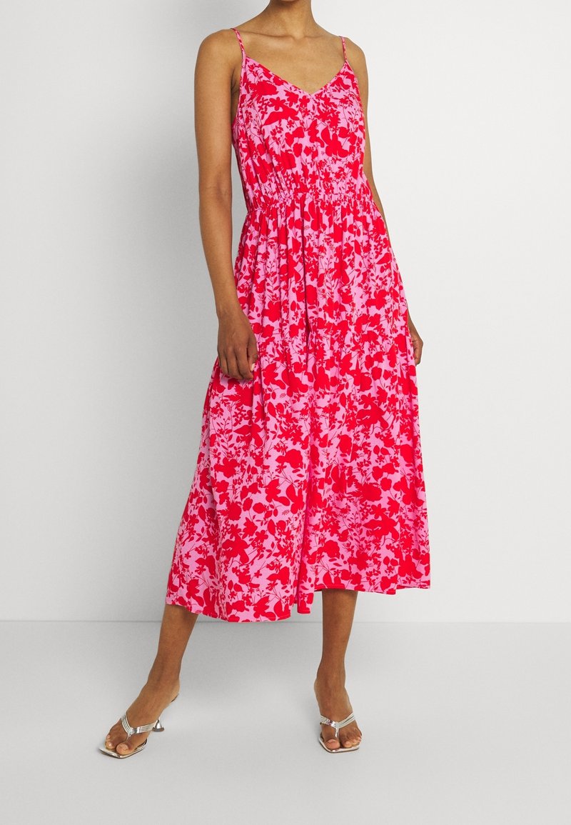Robe midi à fleurs avec un corsage ajusté, des bretelles spaghetti et une taille élastique. Présente des fleurs roses et rouges sur un fond clair.