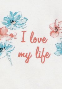 Tekst w stylu odręcznym „Kocham moje życie” na czerwono, otoczony niebieskimi i różowymi kwiatami w stylu akwareli na białym tle.