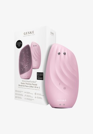 Brosse faciale Sonic rose avec une texture ondulée, des accents métalliques ronds et des icônes de contrôle. Livrée dans une boîte en carton blanc avec logo.