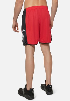Rote und schwarze Sportshorts mit Mesh-Struktur, elastischem Bund und seitlichem grafischen Design einer Figur in Bewegung.