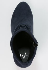 Granatowe botki za kostkę wykonane z miękkiego zamszu, z luźnym krojem, bocznym zamkiem błyskawicznym i okrągłym noskiem. Wewnątrz mają teksturowane wykończenie.