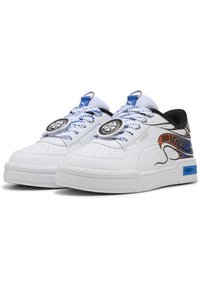 Zapatilla blanca con parte superior de cuero liso, acentos negros, cordones azules, gráficos impresos y detalle de logo circular en la lengüeta.