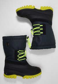 Waterdichte winterlaarzen met een donkergroen geruit textiel bovenwerk, zwarte rubberen zolen, neongele veters en gestructureerde groene buitenzolen.