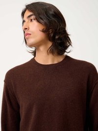 Maglione marrone in materiale morbido, con colletto rotondo, maniche lunghe e una vestibilità rilassata con una sottile texture.