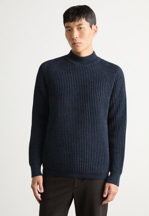 Maglione girocollo a coste blu navy, maniche lunghe, con motivo a maglia testurizzato, silhouette aderente e dettagli delle cuciture distintivi.