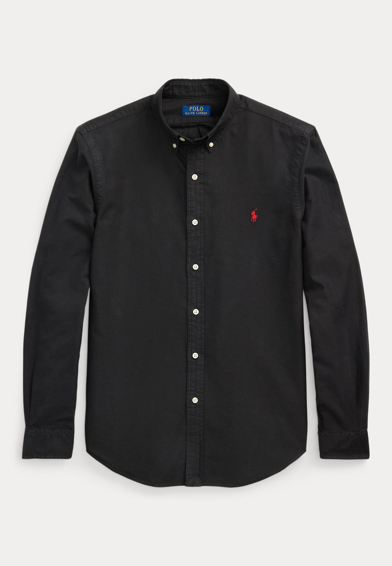 Črna bombažna srajca s kratkimi rokavi in uskim ovratnikom, bele gumbe ter rdečim vezenim logotipom na levem prsnem delu. Prilagojen kroj.