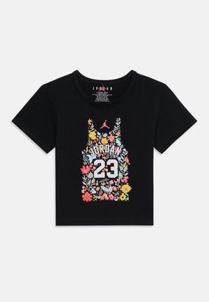 Μαύρο crop top με κοντό μανίκι, σχεδιασμένο σαν φλαουράτο μπασκετικό φανελάκι, με την επιγραφή "JORDAN", τον αριθμό 23 και ροζ λογότυπο Jumpman στο κέντρο μπροστά.