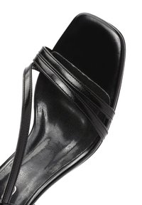 Sandal nero con punta quadrata, caratterizzato da sottili cinturini e una finitura lucida e slanciata. La soletta ha una consistenza liscia con motivi sottili.