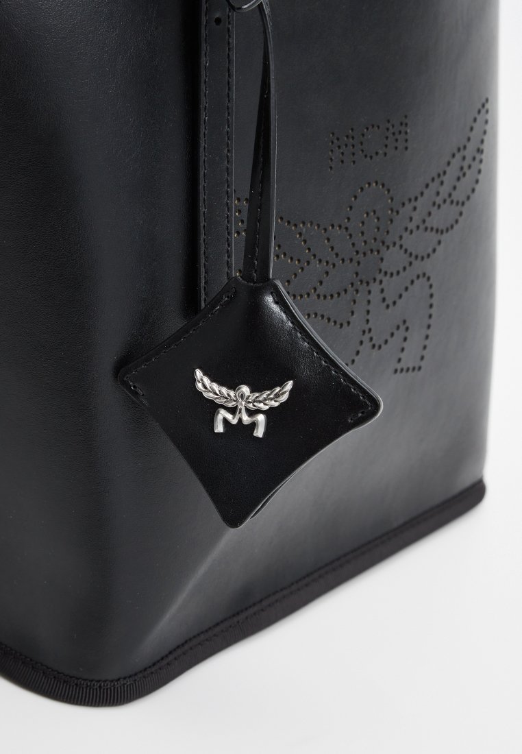 Schwarze Ledertasche mit glatter Textur, Logo-Prägung und einem abnehmbaren Lederanhänger mit silbernen Hardware-Details.