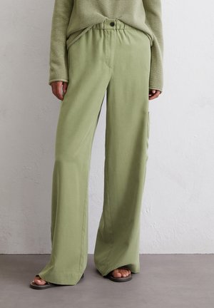 Light green wide-leg trousers made of soft fabric, featuring an elastic waistband with a button, side pockets, and a relaxed fit.