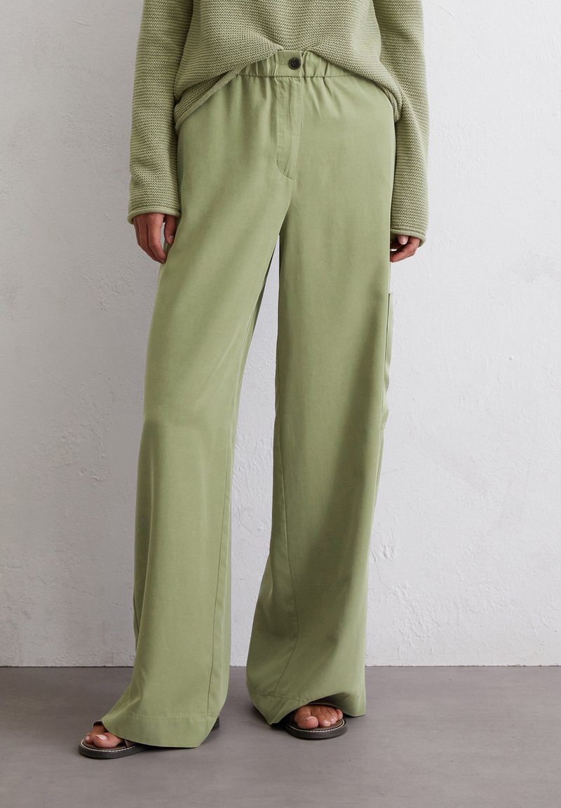 Lichtgroene wijde broek van zacht materiaal, met een elastische tailleband met een knoop, zijzakken en een relaxed fit.