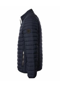 Marinblå quiltad pufferjacka med hög krage, dragkedjeficka på sidan och cirkulär logopatch på ärmen.