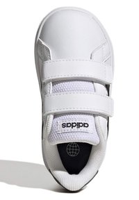 Bílé tenisky s syntetickým svrškem, dvěma suchými zipy, síťovaným jazykem a černou podrážkou. Na jazyku a patě se nachází logo Adidas.