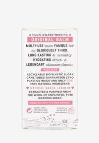 Packaging for a multi-use balm, featuring a white background, bold black and pink text. Includes details on recyclable materials and ingredients.