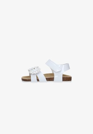 Sandalo bianco per bambini con due cinturini, chiusura in velcro alla caviglia, plantare in sughero e fiore bianco decorativo sulla fascia anteriore.