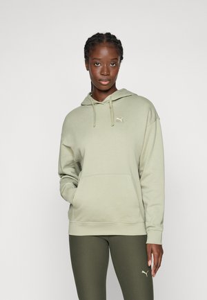 Lys grønn hoodie med lommepose foran, hette med snor, og liten hvit logo på brystet. Kombinert med mørkegrønne leggings.