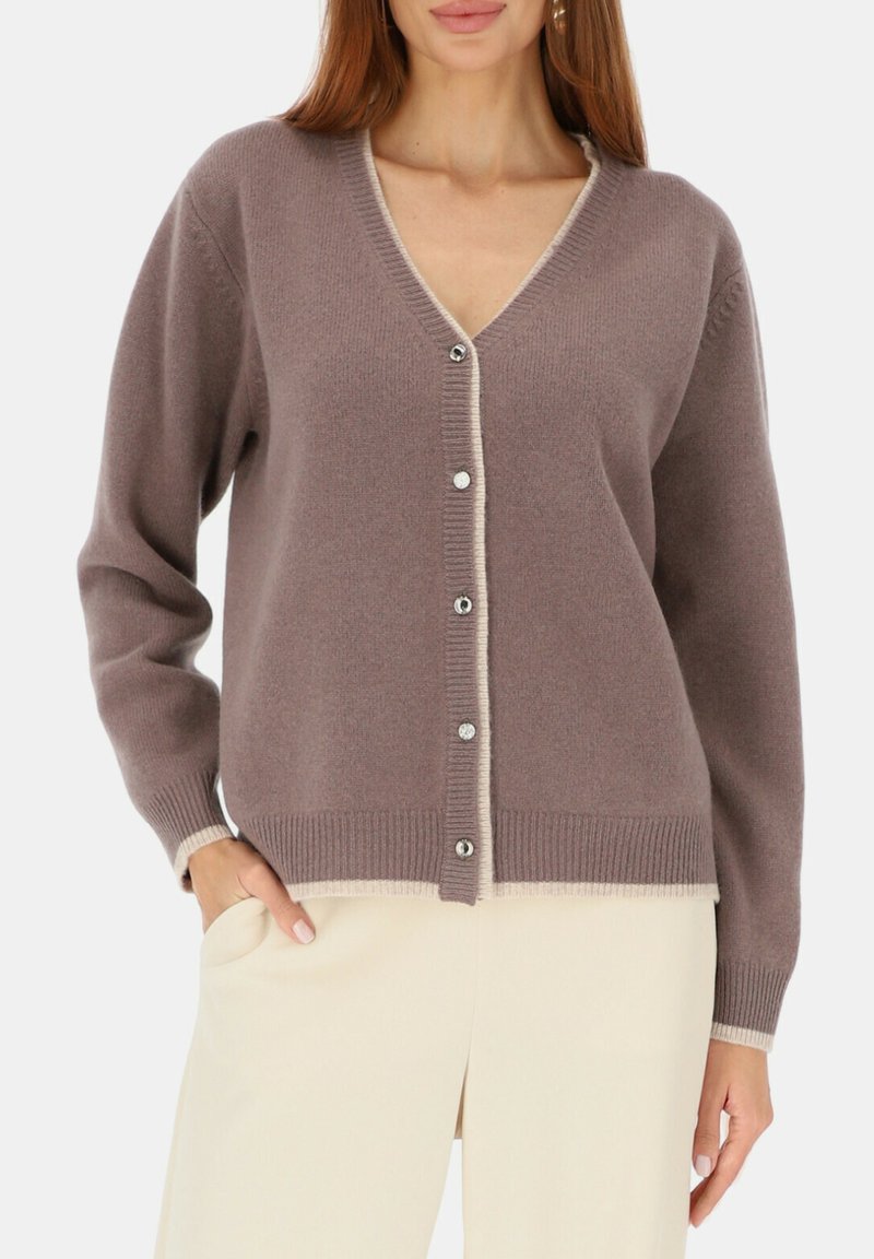 Sweter w kształcie litery V w miękkim, różowawym tkanym materiale z kontrastowymi kremowymi wykończeniami. Posiada srebrne guziki oraz prążkowane mankiety i dół, oferując luźny krój.