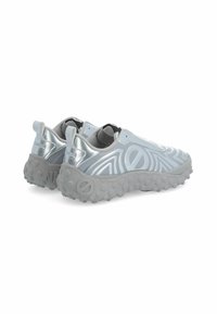 Silberne synthetische Slipschuhe mit einem strukturierten Muster, runder Form und einer grauen Gummisohle mit kleinen Stollen für Grip.