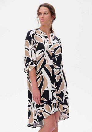 Robe noire avec des motifs de feuilles blancs et beiges, fermeture à boutons, et manches retroussées. Tissu léger avec une coupe fluide.