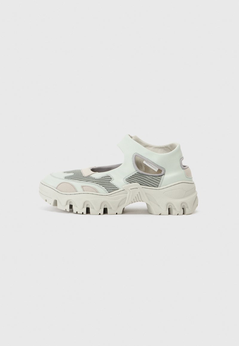 Light mint green and gray sneakers with mesh overlays, thick white sole, and padded collar. Distinctive chunky design with cut-out details.