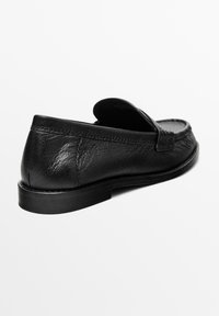 Schwarze Leder Slipper mit runder Zehenform, glatter Textur und minimalen Nähten, ausgestattet mit einer flachen Sohle.