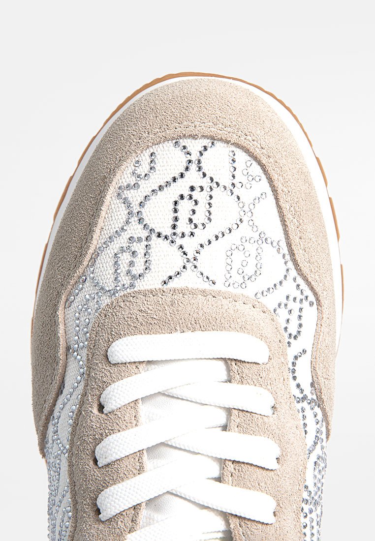 Sneaker con tomaia in tela bianca con motivo a rombi e strass argentati, completata da una punta in suede beige e lacci bianchi.