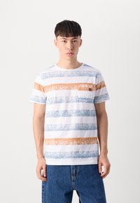 Camiseta de algodón a rayas con líneas horizontales en azul, naranja y blanco, con un pequeño bolsillo en el pecho. Cuello redondo y mangas cortas.