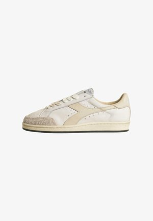 Sneaker basse beige con punta in suede, dettagli perforati e lacci piatti. Presentano una suola color crema e un branding discreto.