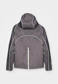 Gray hooded jacket featuring white piping, a front zipper, and a simple design. The fabric appears smooth with a slightly shiny texture.