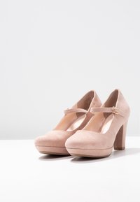 Scarpe Mary Jane in suede rosa con punta rotonda, cinturino regolabile e tacco a blocco di 10 cm, dotate di una piattaforma e una texture liscia.