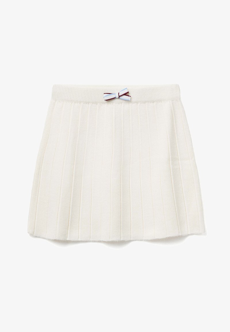 Bílá plisovaná sukně s žebrovanou texturou. Obsahuje vzorovaný pas a malou modro-vínovou mašličku na přední části.