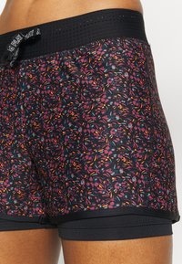 Svarta shorts med ett blommönster som har lila, orange och turkosa accenter. Mjuk tyg, elastisk midja med varumärke och figurnära design.