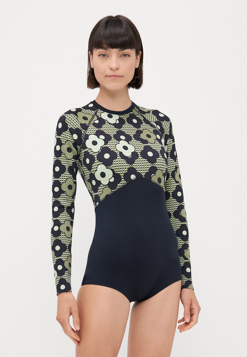 Maillot de bain à manches longues avec un motif floral noir et vert, partie inférieure unie navy, fabriqué en tissu extensible pour le confort et l'ajustement.