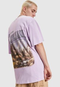 Lilac cotton t-shirt featuring a bear and forest graphic on the back, with a relaxed fit and short sleeves.