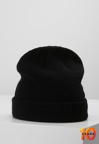 Beanie nero a maglia con un motivo a coste testurizzate, dotato di un risvolto. Realizzato in materiale morbido e flessibile per il massimo comfort.