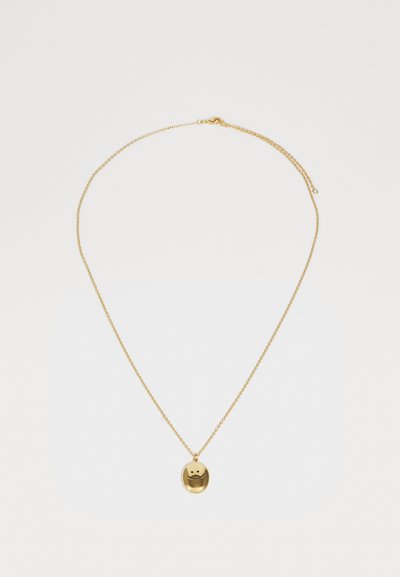 Guldkæde med en rund vedhæng, der har et smilende ansigt design. Kæden er sart og består af sammenkoblede, fine led.
